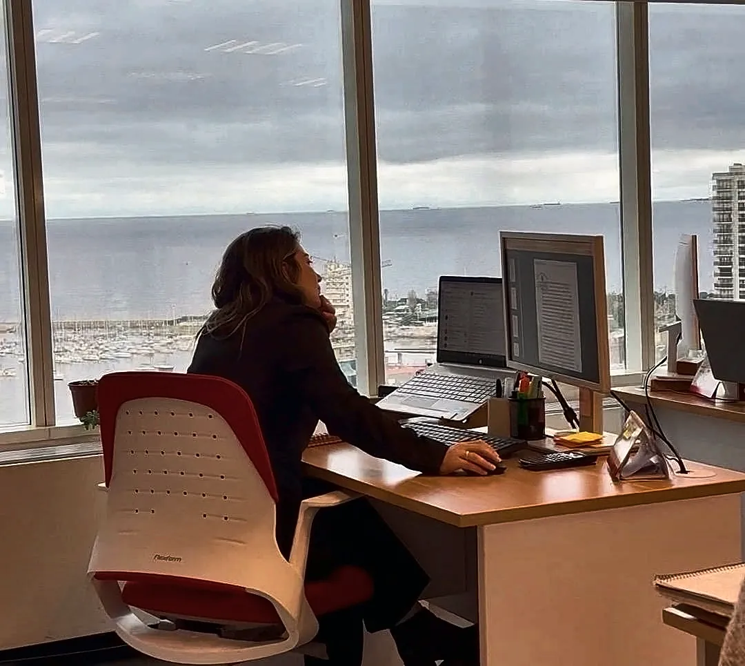 Integrante de VDC Estudio Contable en su escritorio, con vista al puerto del Buceo